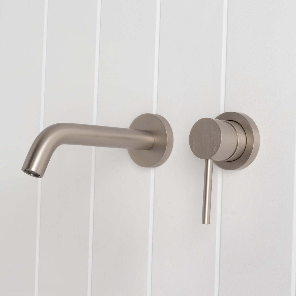 Milano Wall Spout Plus Wall Mixer in Brushed Nickel, side profile of curved spout and mixer, white vertical-panelled wall