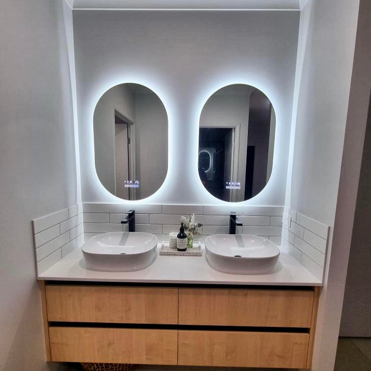 Pair of Oval Smart LED Mirrors Complementing Twin Sinks in Couples' Bathroom