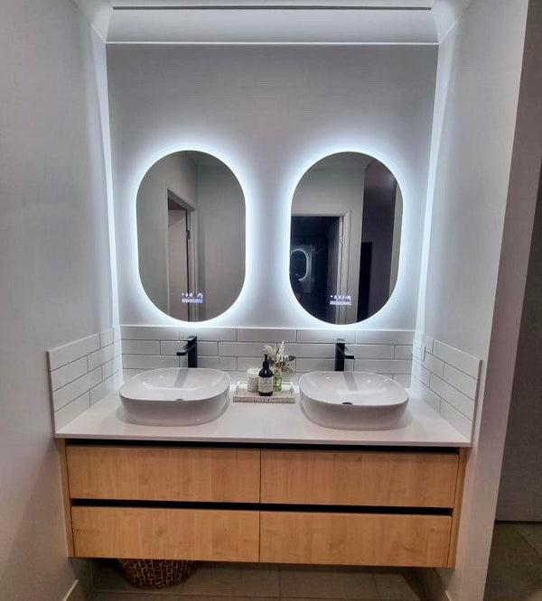 Pair of Oval Smart LED Mirrors Complementing Twin Sinks in Couples' Bathroom