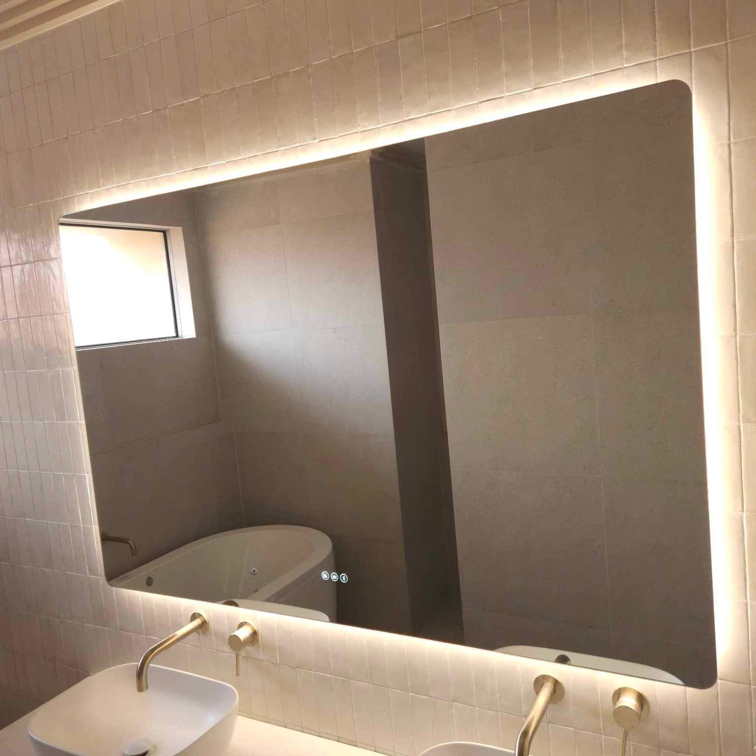Gold, Beige, White Bathroom featuring Large Smart Backlit LED Mirror Above Double Sink