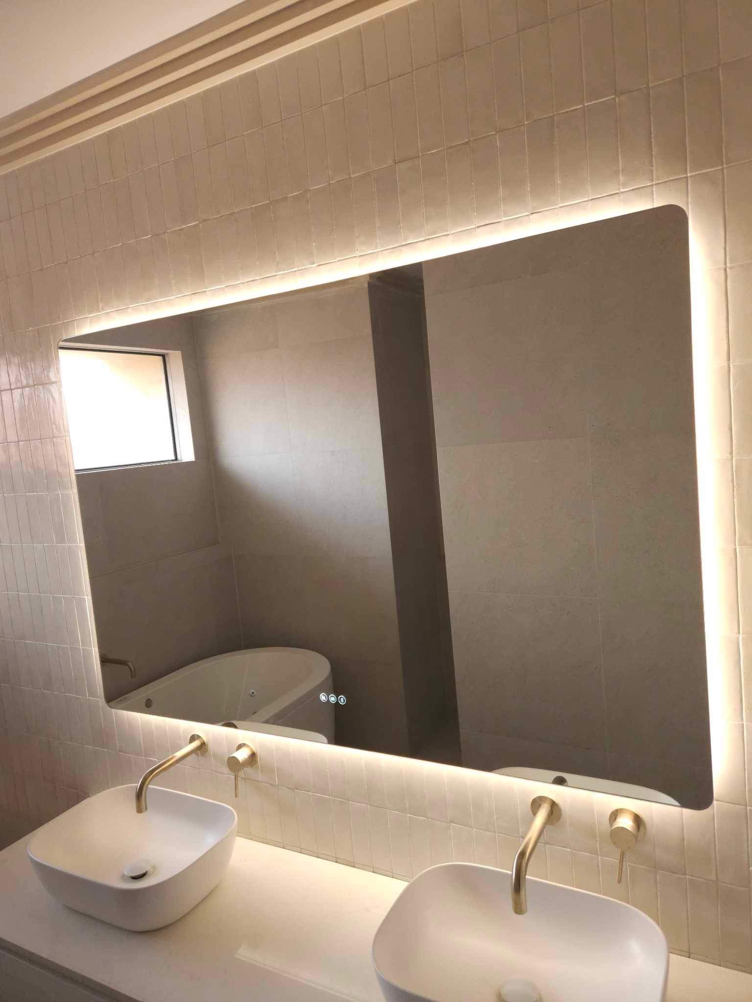 Gold, Beige, White Bathroom featuring Large Smart Backlit LED Mirror Above Double Sink