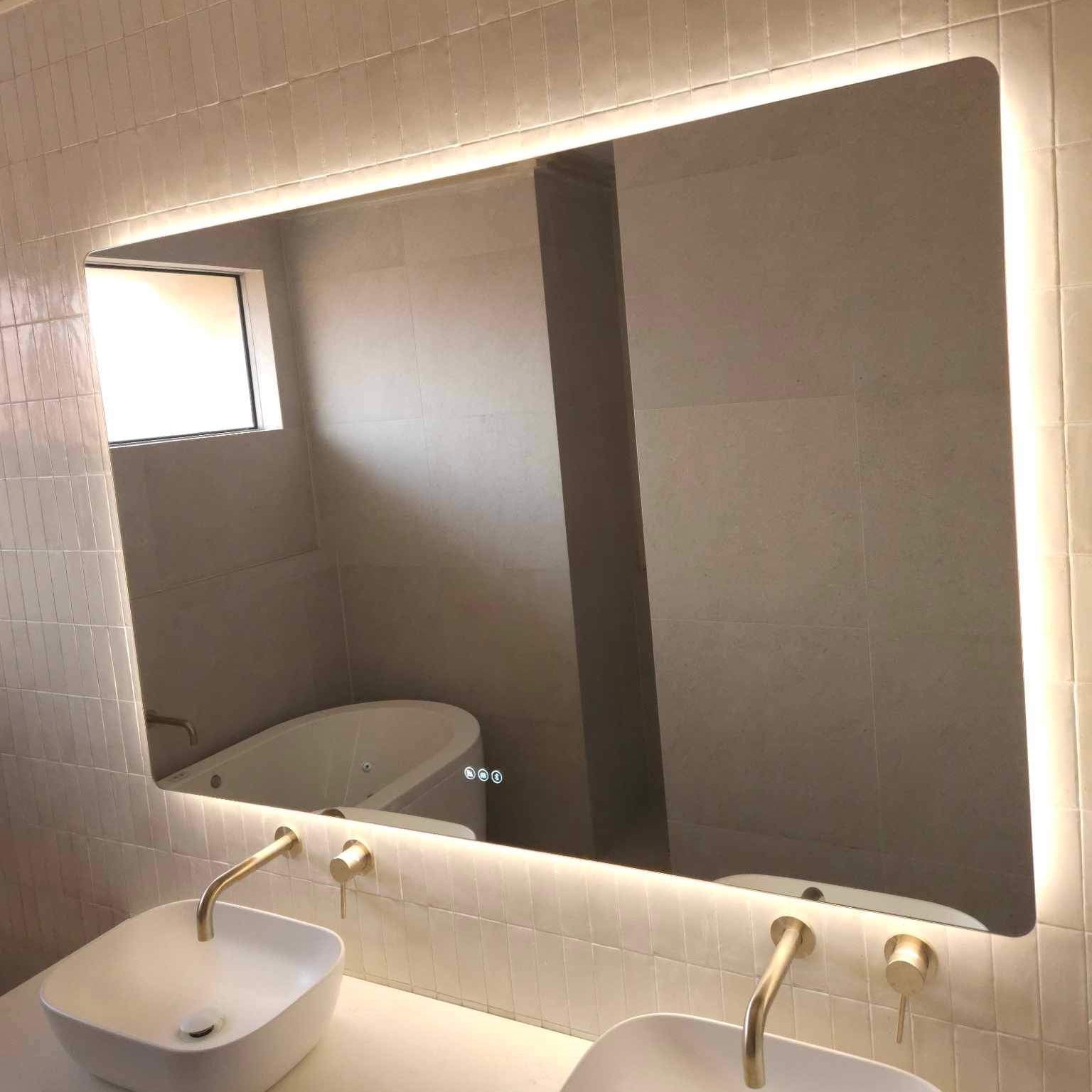 Gold, Beige, White Bathroom featuring Large Smart Backlit LED Mirror Above Double Sink