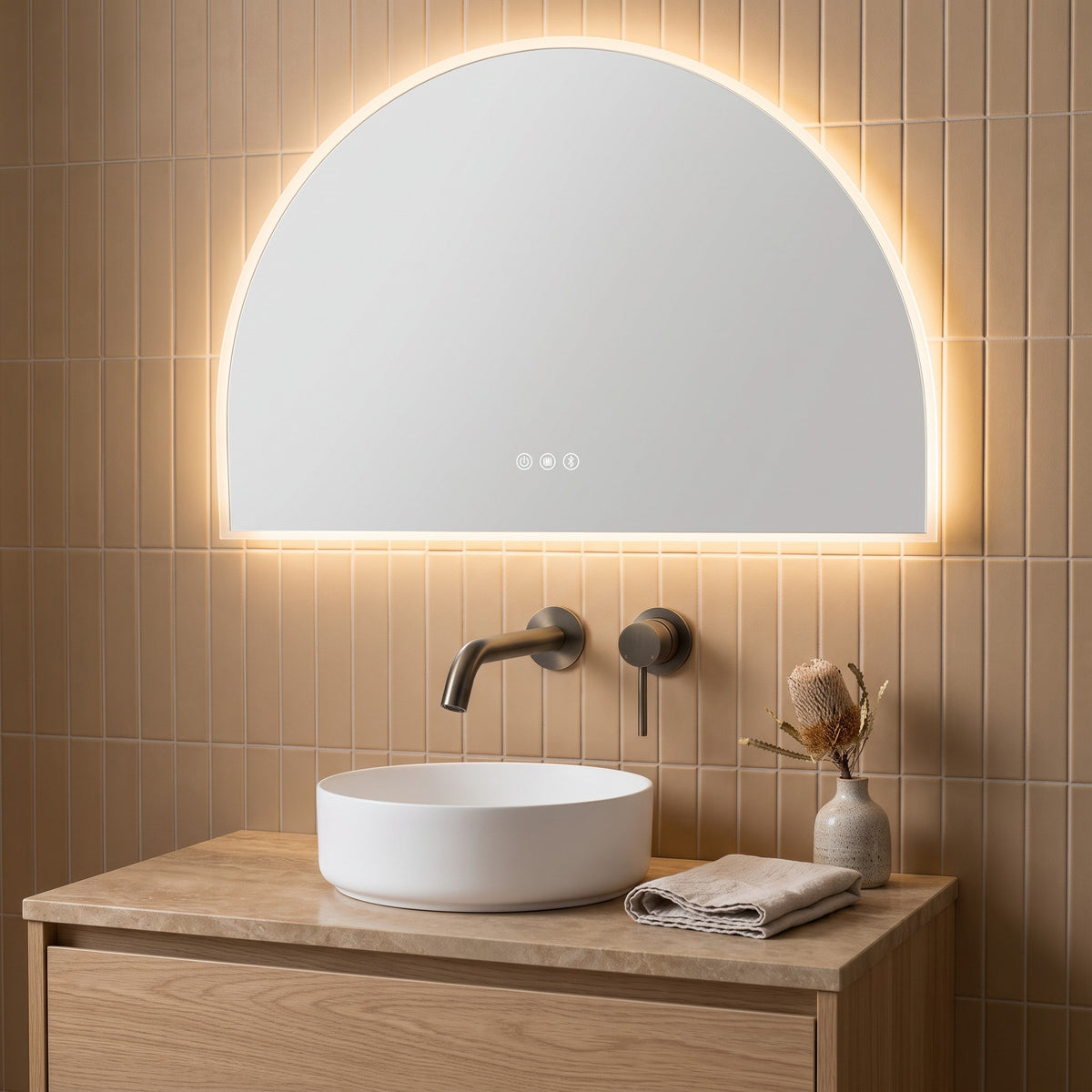 Milano Wall Spout Plus Wall Mixer in Antique Brass, above a white vessel basin on tan tiles below an arch mirror