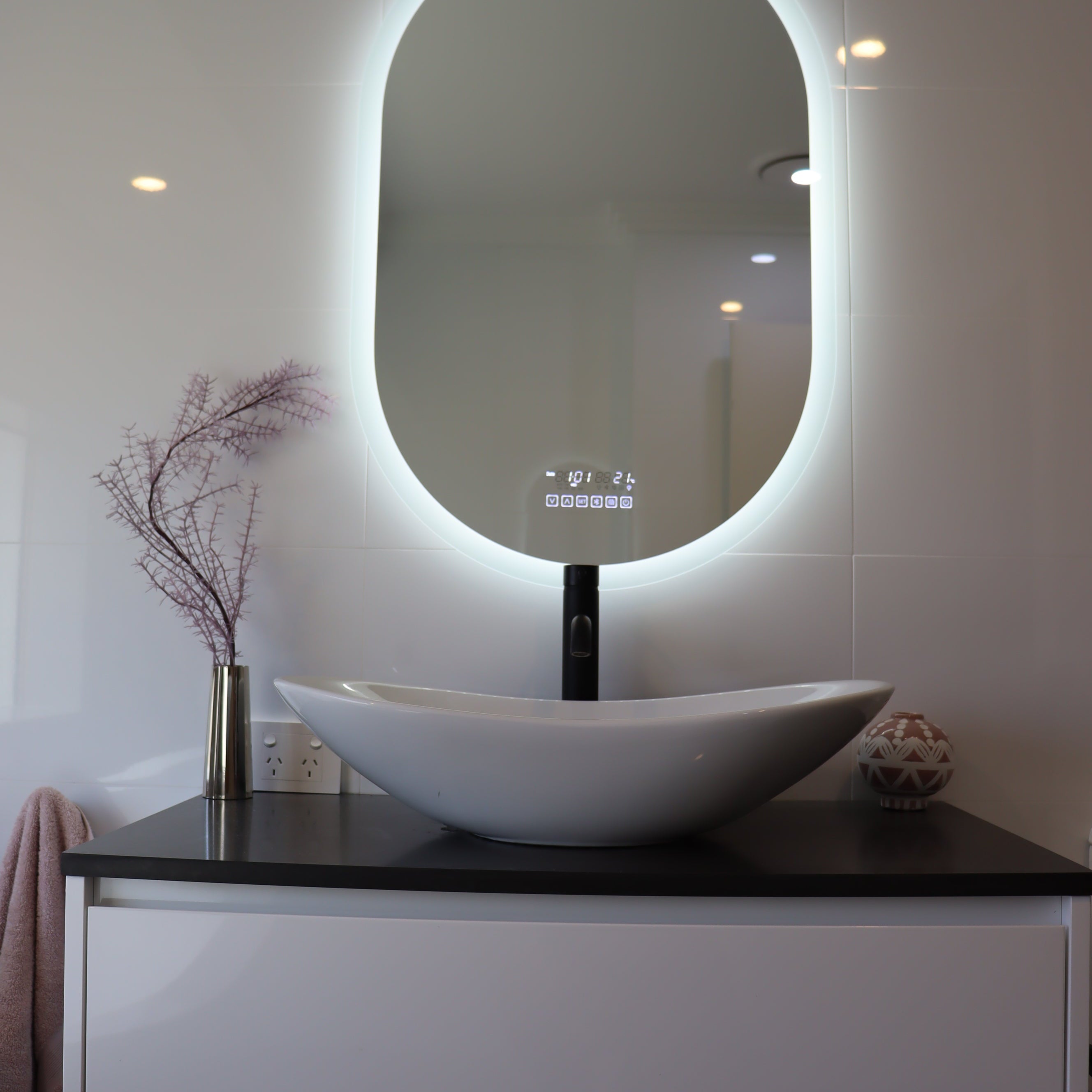 Vanity space with Smart LED mirror emitting brilliant white backlit light matched with white cabinet