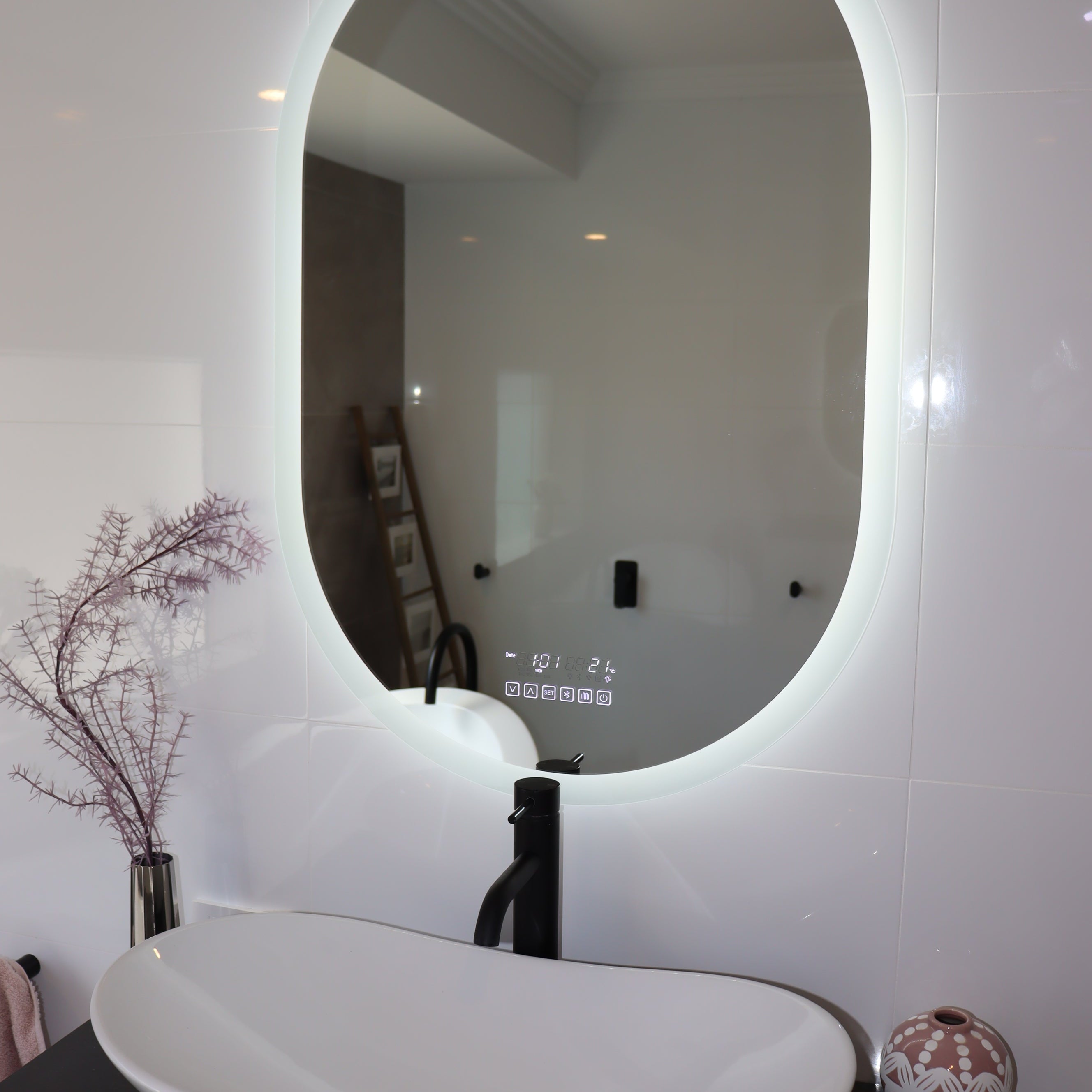 Oval Smart LED mirror with brilliant white backlit LED light and black bathroom countertop