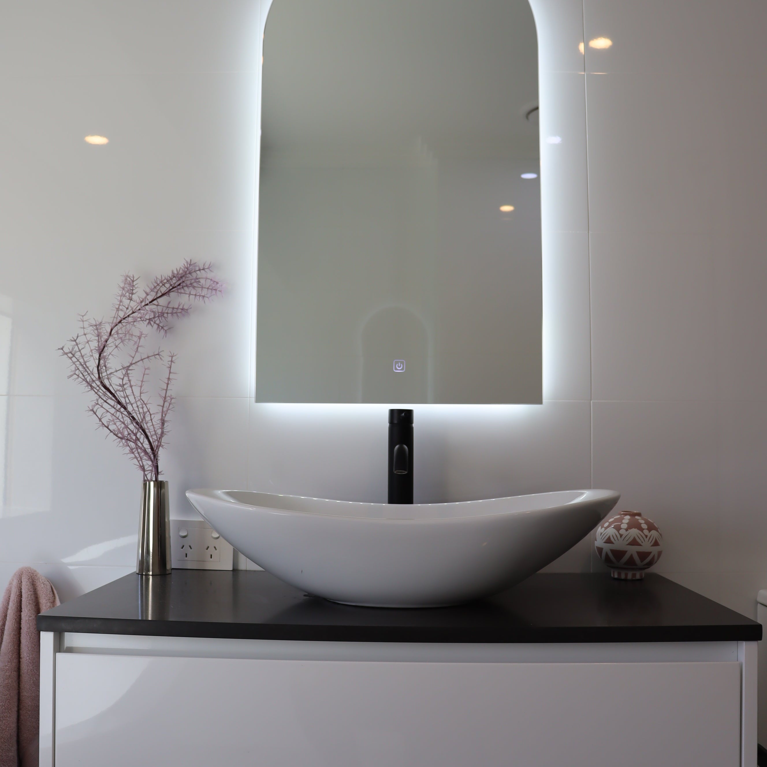 Vanity Space in White Glossy Bathroom with Lighted Arch-Shaped Backlit LED Mirror