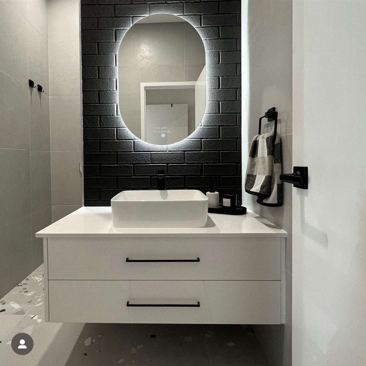 Black subway-tiled bathroom foyer with LED Mirror, floating cabinet, and passage to the shower area
