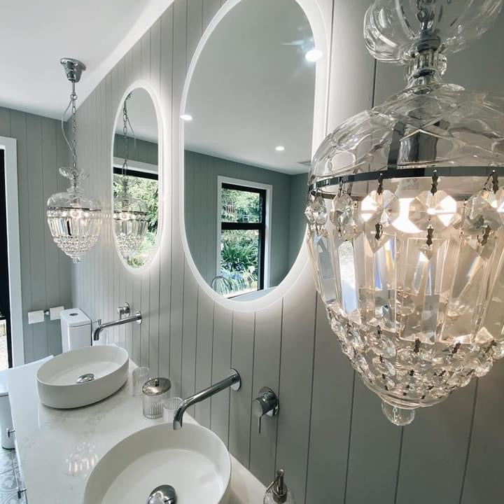 Elegant bathroom from smart LED mirrors, chandelier-like pendant lights, white scheme, grey walls