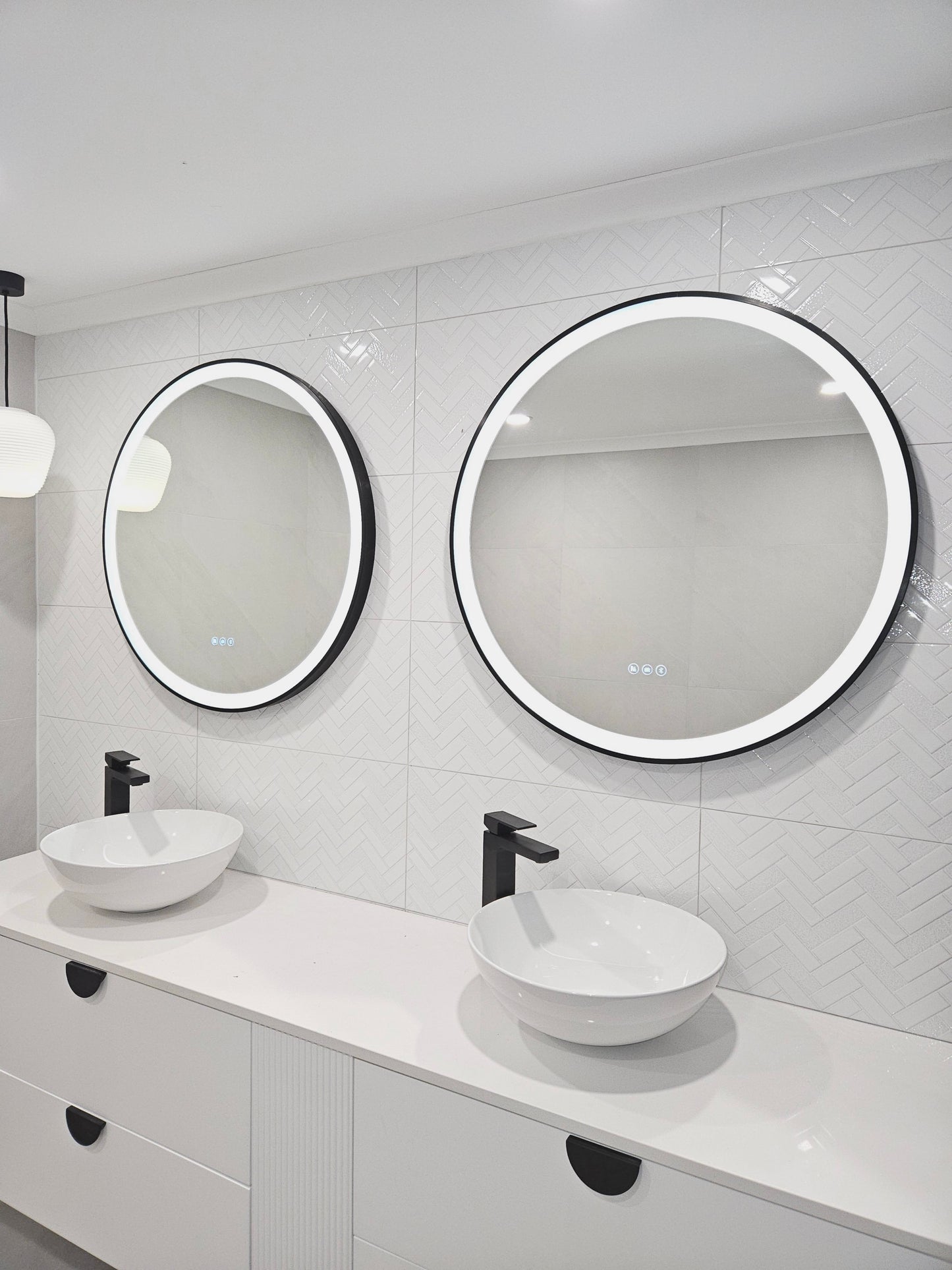 Dual Smart LED mirrors with black frames in an All-White bathroom with Black Contrasting Accents