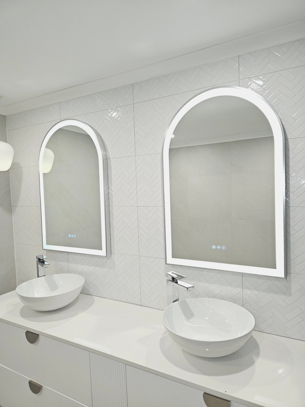 Elegant duo of Arch-shaped Smart LED Mirrors in minimalist white-on-white bathroom.