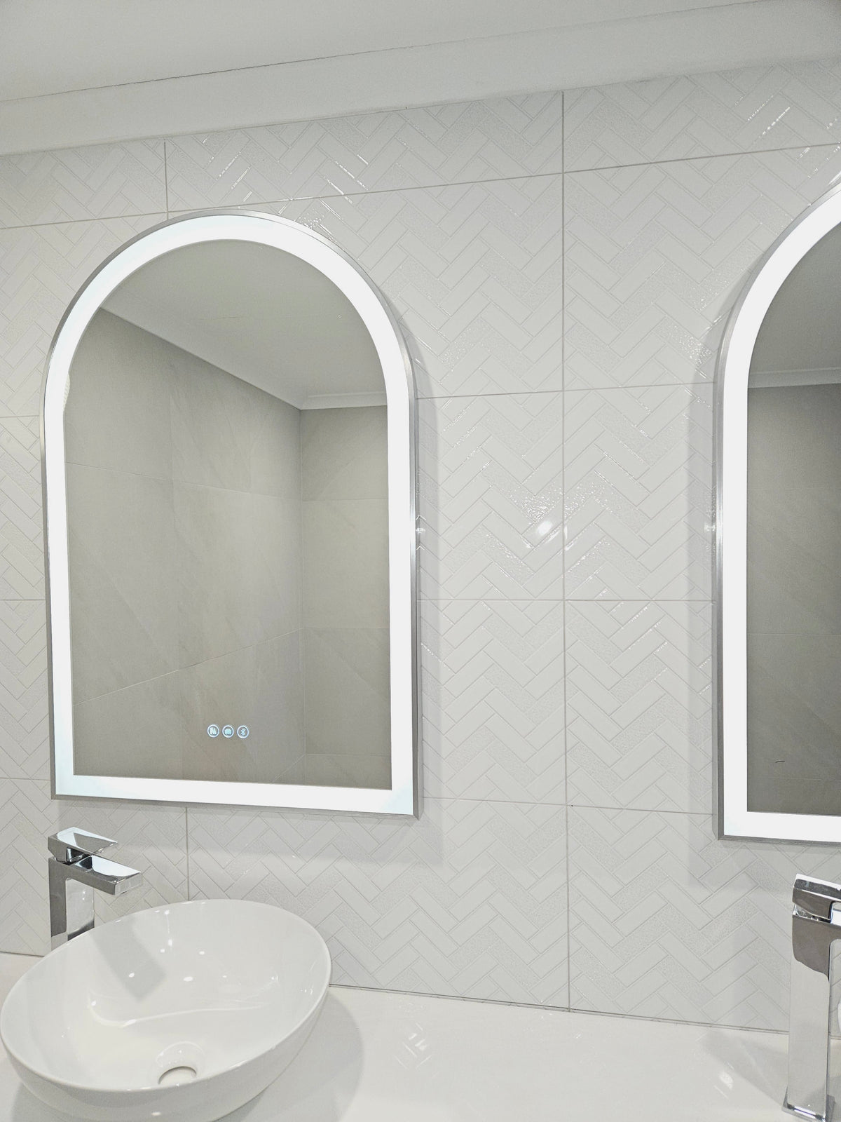 Double Smart LED Mirrors with Arch-shaped design in elegant white-on-white bathroom.