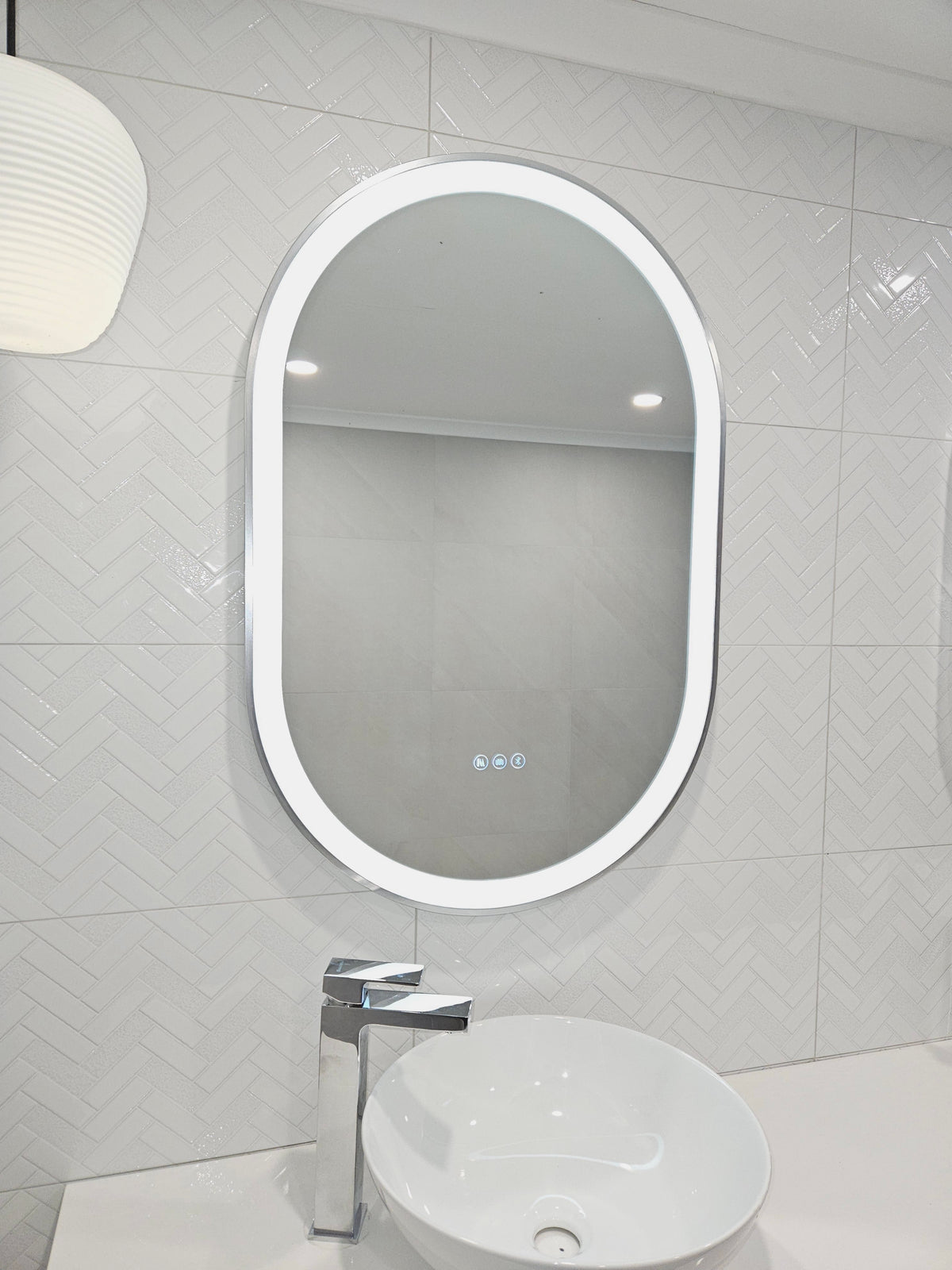 Stylish Silver Frame Pill-Shaped Smart Mirror with Front LED Lights in White Bathroom
