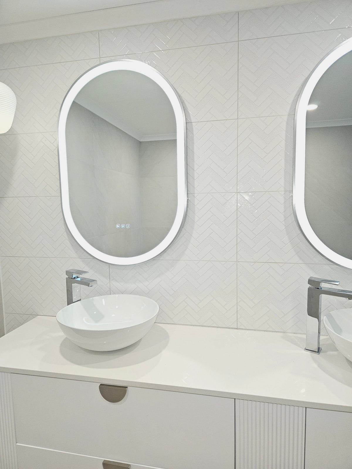 Pair of chic pill-shaped Silver Frame Smart LED Mirrors in contemporary white bathroom