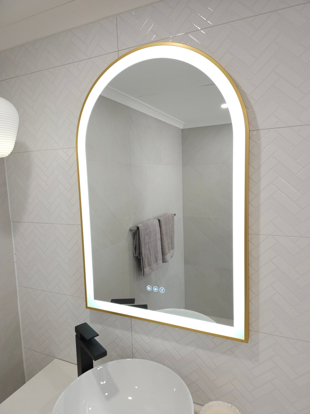 White Tiled Surface with Arch-Shaped Gold-Framed Mirror