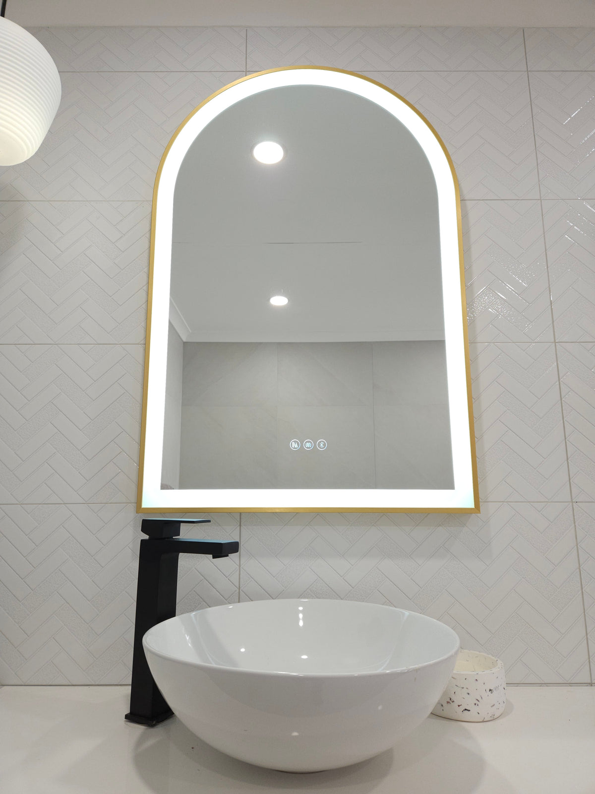 Front View of Gold-Framed Arch-Shaped Mirror in White Powder Room