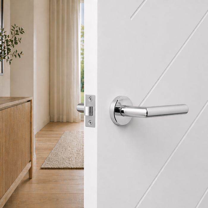 Santorini Door Handle in Chrome, polished lever handle and latch on the edge of an open white grooved door
