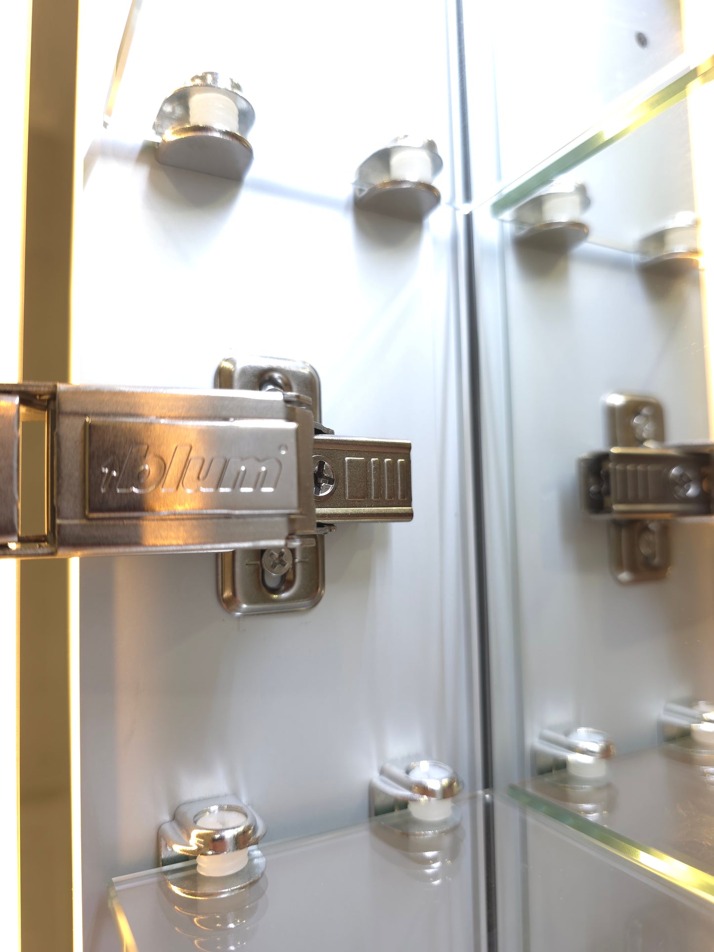 Close up view of Frameless LED mirror cabinet with adjustable glass internal storage shelves and Blum brackets