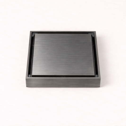 Granada Tile Insert Floor Waste in Brushed Gunmetal, three-quarter view of the cover on a plain white background
