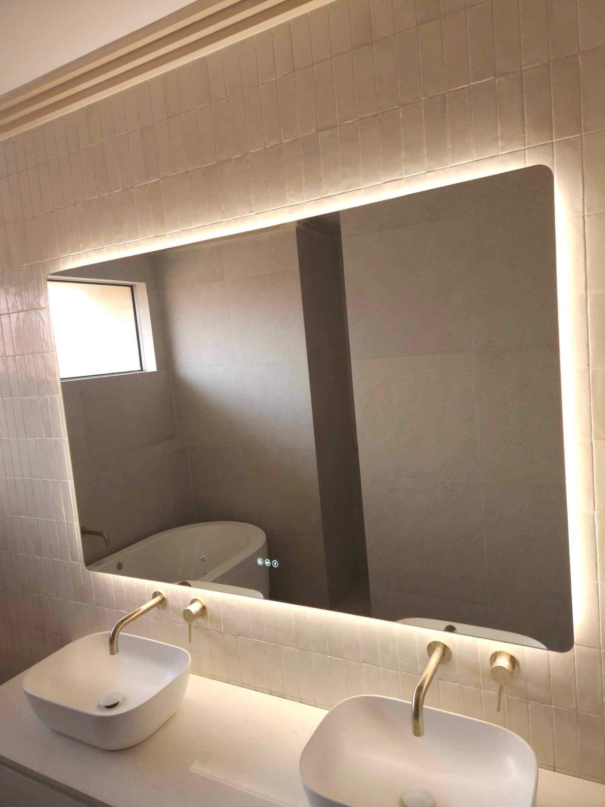 Gold, Beige, White Bathroom featuring Large Smart Backlit LED Mirror Above Double Sink