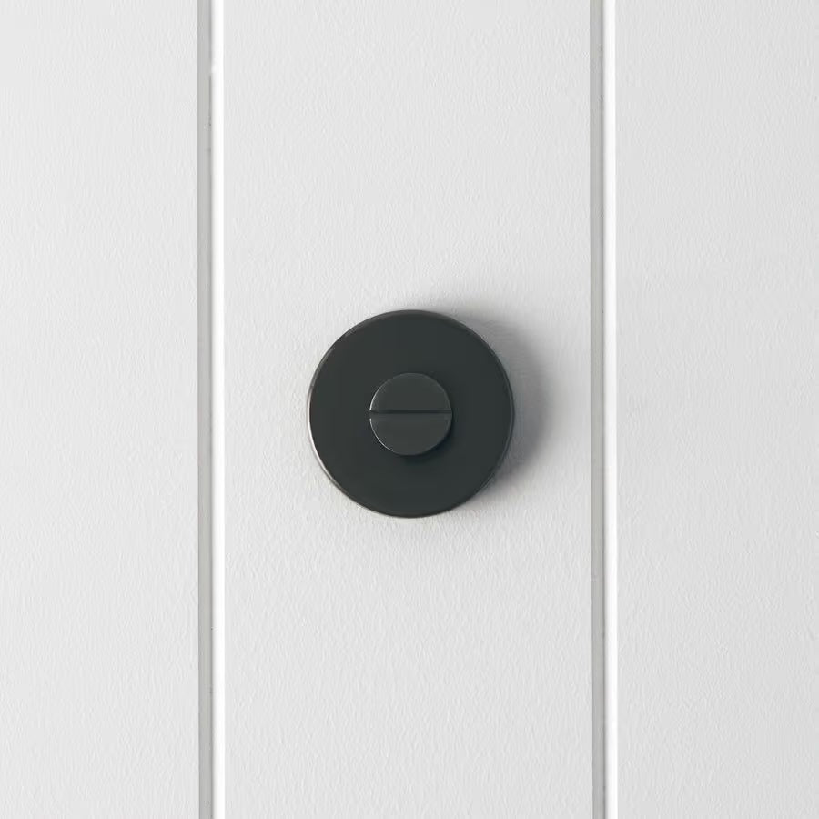 Prague Door Lock in Brushed Gunmetal, front view of the slotted emergency release on a white vertical-panelled wall
