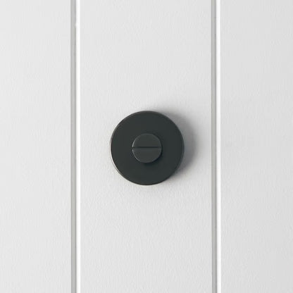 Prague Door Lock in Brushed Gunmetal, front view of the slotted emergency release on a white vertical-panelled wall