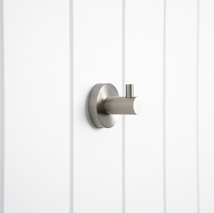 Copenhagen Robe Hook in Brushed Nickel, three-quarter view on a white vertical-panelled wall
