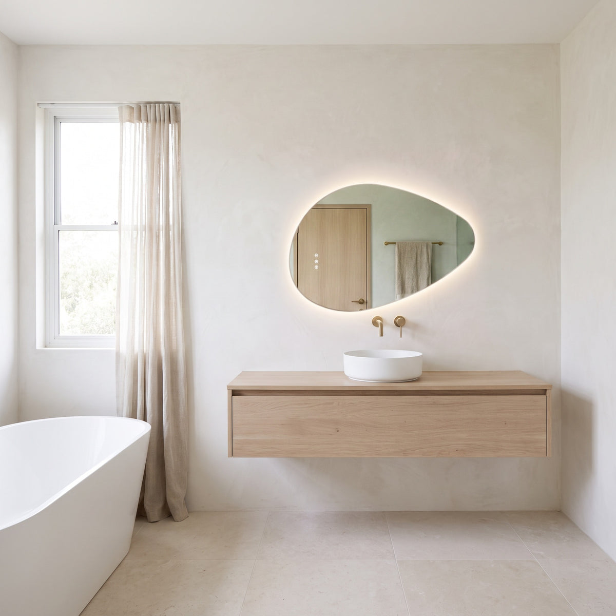 The Sorrento frameless backlit LED mirror, 800 x 550mm, above an oak vanity in a bright bathroom with a freestanding bath