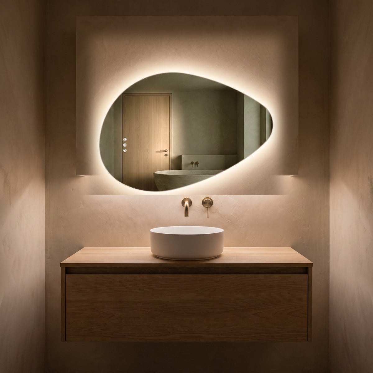 The Sorrento frameless backlit LED mirror, 800 x 550mm, glowing in a dim evening bathroom above an oak vanity and basin