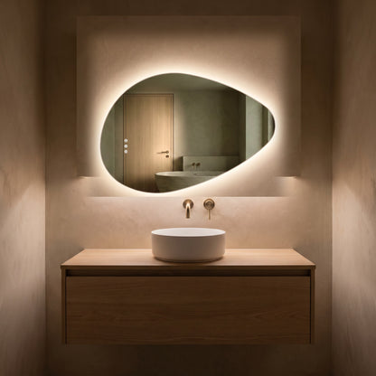 The Sorrento frameless backlit LED mirror, 800 x 550mm, glowing in a dim evening bathroom above an oak vanity and basin
