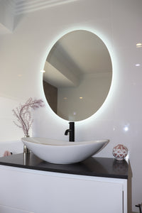 Warm and Airy Bathroom Atmosphere with Blended Lights from Window and Oval LED Mirror
