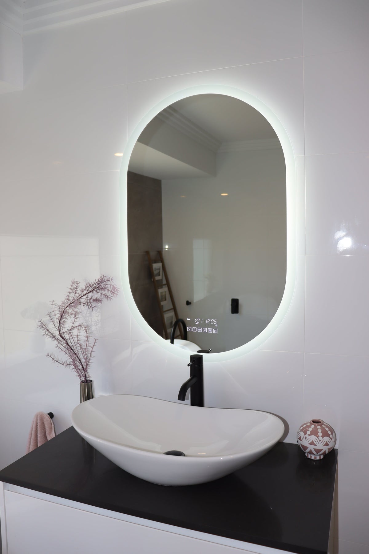 Serene white LED mirror vanity with black countertop and nature-inspired decor