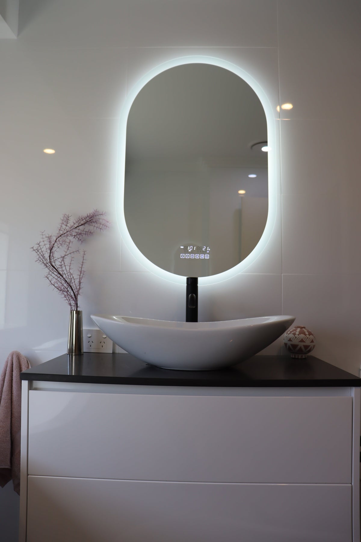 Vanity space with Smart LED mirror emitting brilliant white backlit light matched with white cabinet