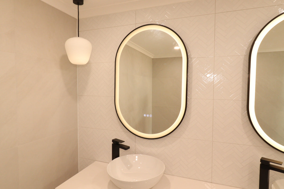 Twin Oval Smart LED Mirrors in Cream-Themed Powder Room with Striking Black Accents