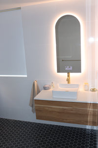 Bright and inviting vanity space with warm white light from curved smart LED Mirror and main lights