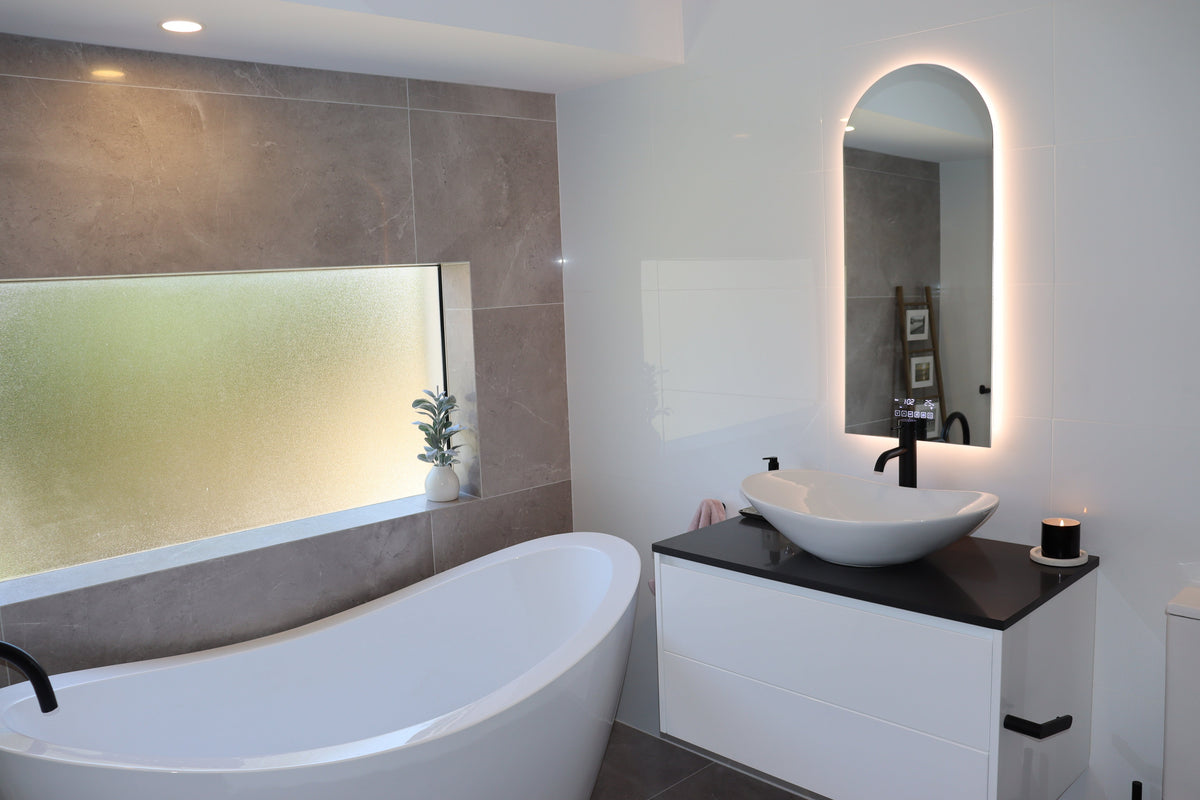 Split-design bathroom: Glossy white tiles, classy vanity, grey matte tiles, tinted window, bathtub.