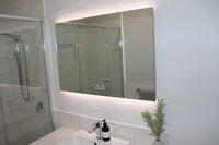 Top-Down Diagonal View of Vanity Mirror, Sink, and Shower Enclosure in White Bathroom