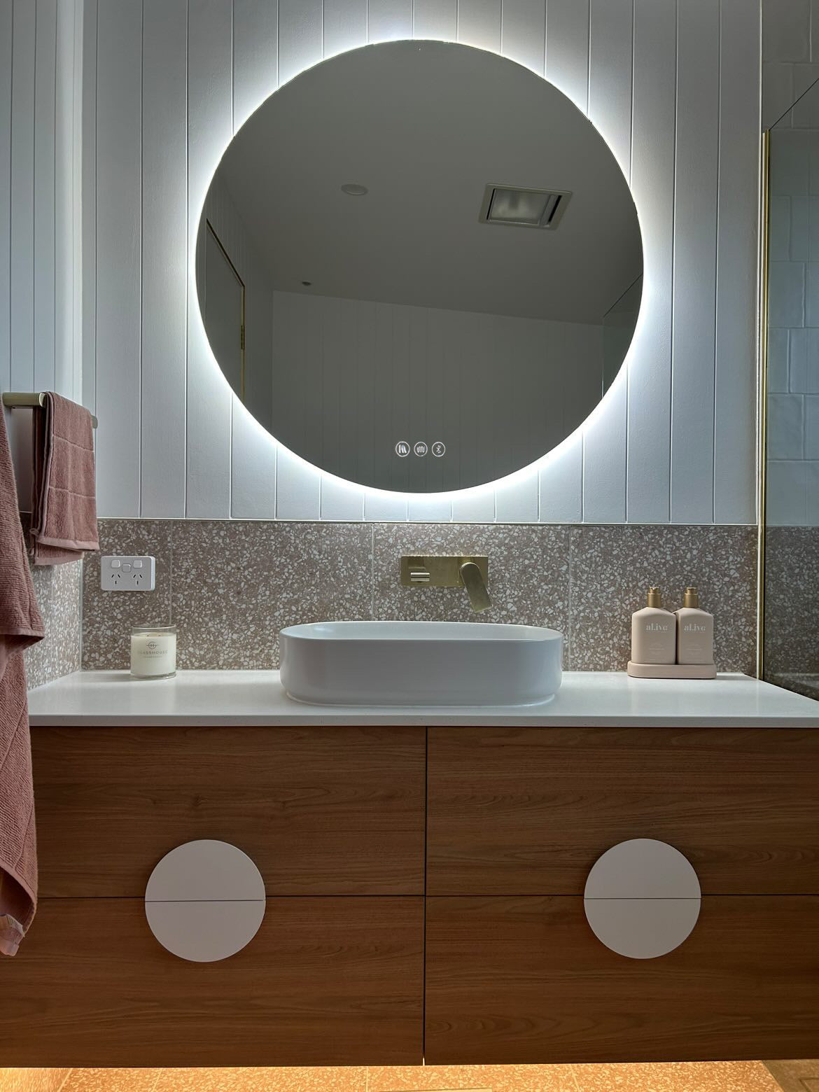 Versatile Circle Backlit LED Mirror in white, light brown, and gold themed bathroom.