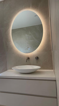 Vanity Area with Round Smart Backlit LED Mirror, White Vessel Sink, Cabinet in Beige and White Theme