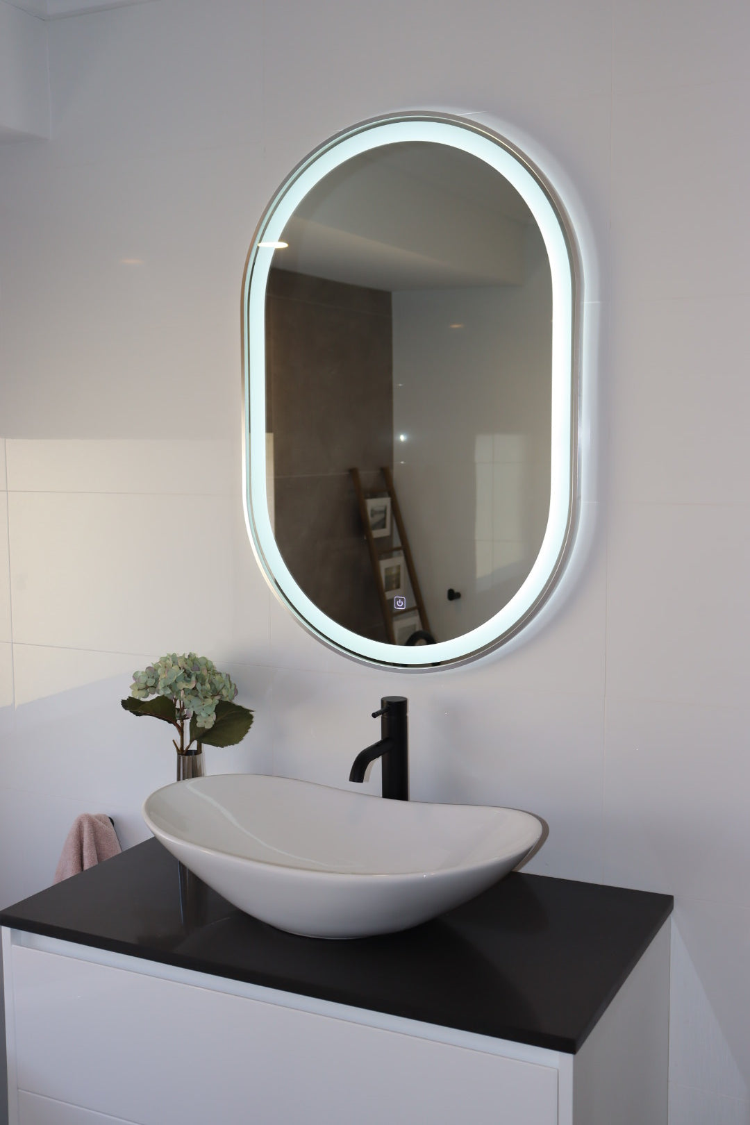 Chic Oval LED Mirror in Modern White Bathroom with Black Accents and Stylish Wall Tiles