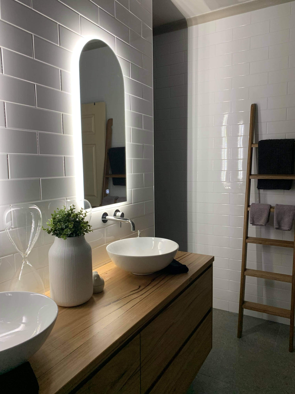 Right LED Foyer Mirror in Couple's Bathroom, Mounted on White Subway Tiles